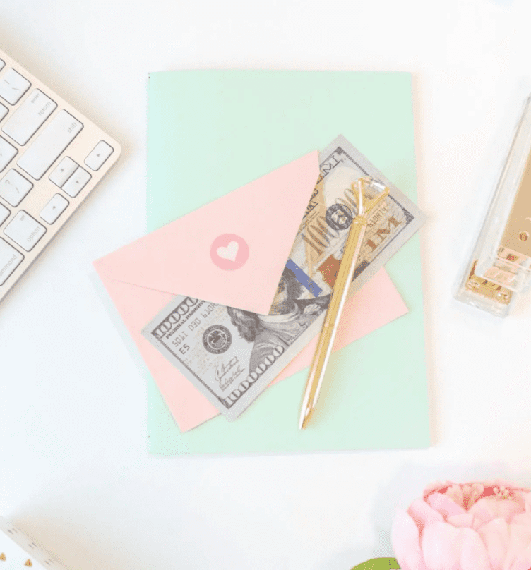 Pink envelope holding money on a desk