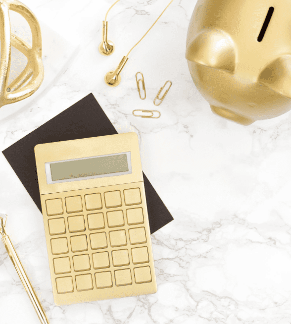 Gold Calculator and piggy bank on a white marble desk
