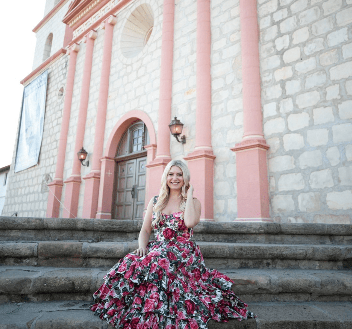 Emily Williams Sitting on the Steps in a Floral Dress