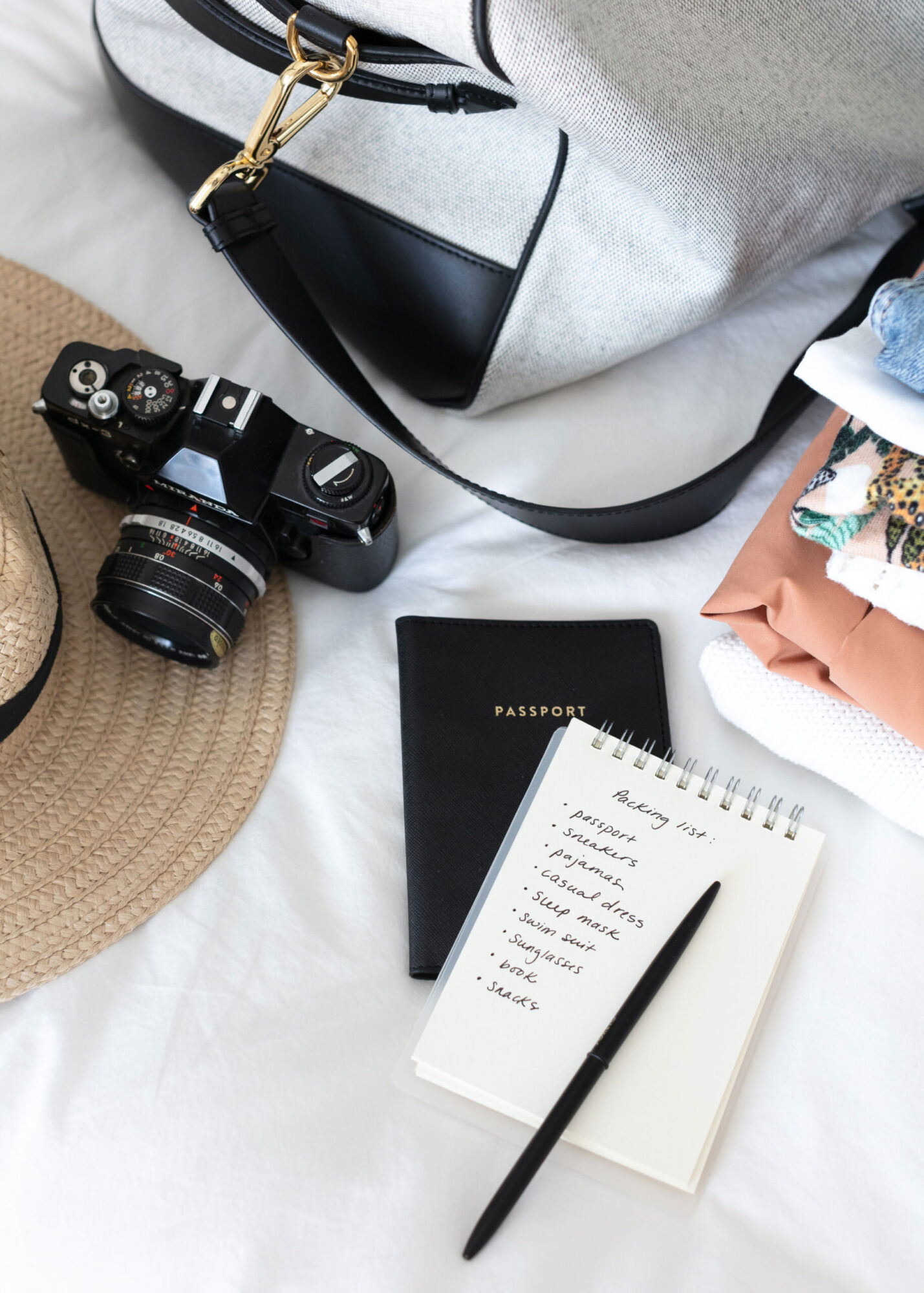 international travel essentials such as bag, hat, passport, clothes.